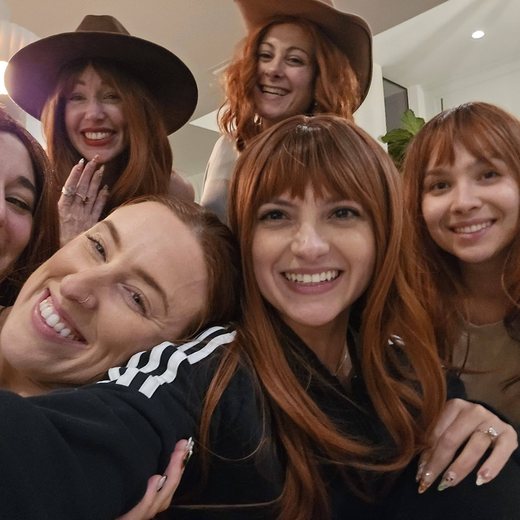 Rena and friends laughing together in matching red wigs